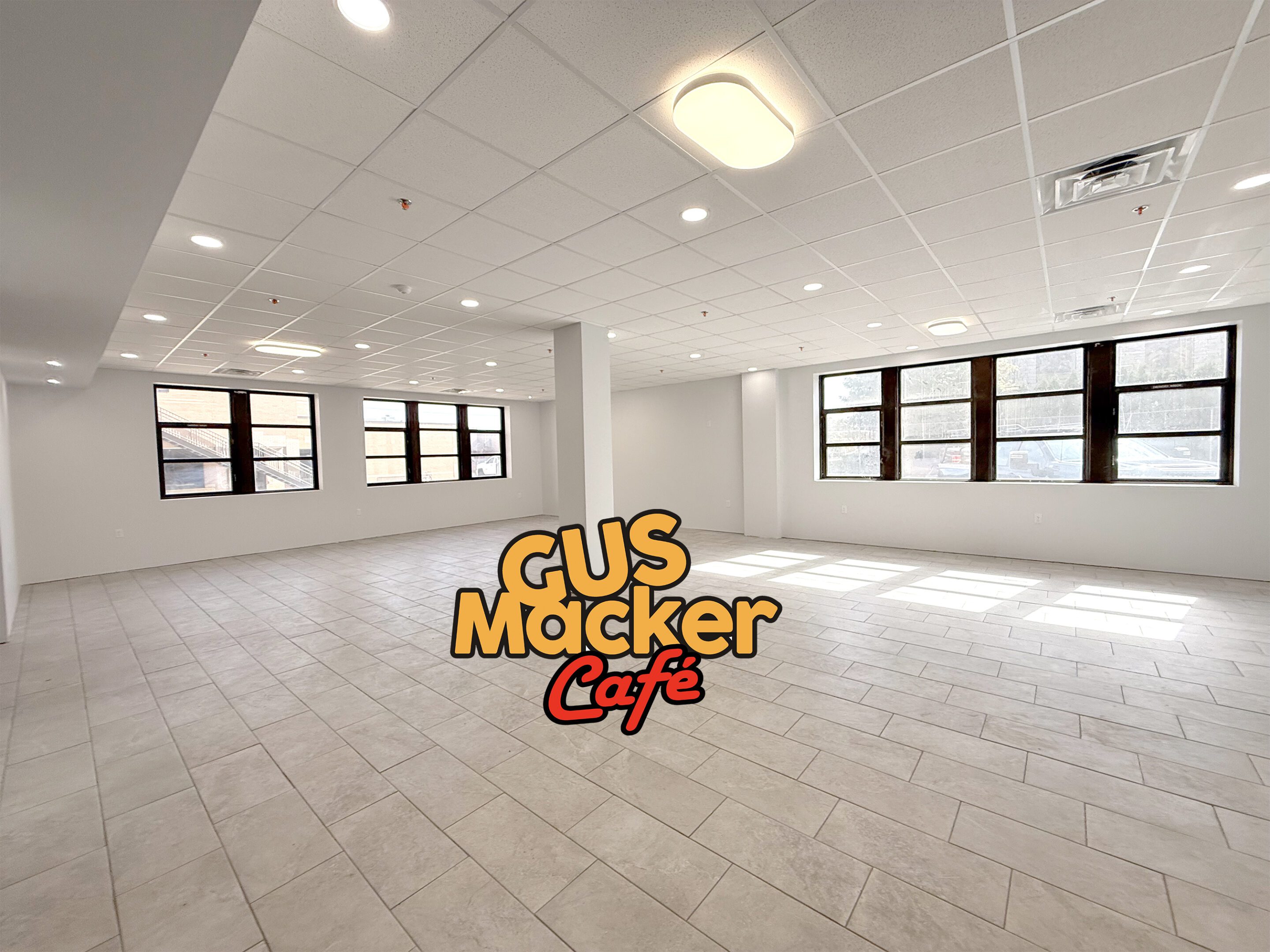 Empty room with large windows and ceiling lights.