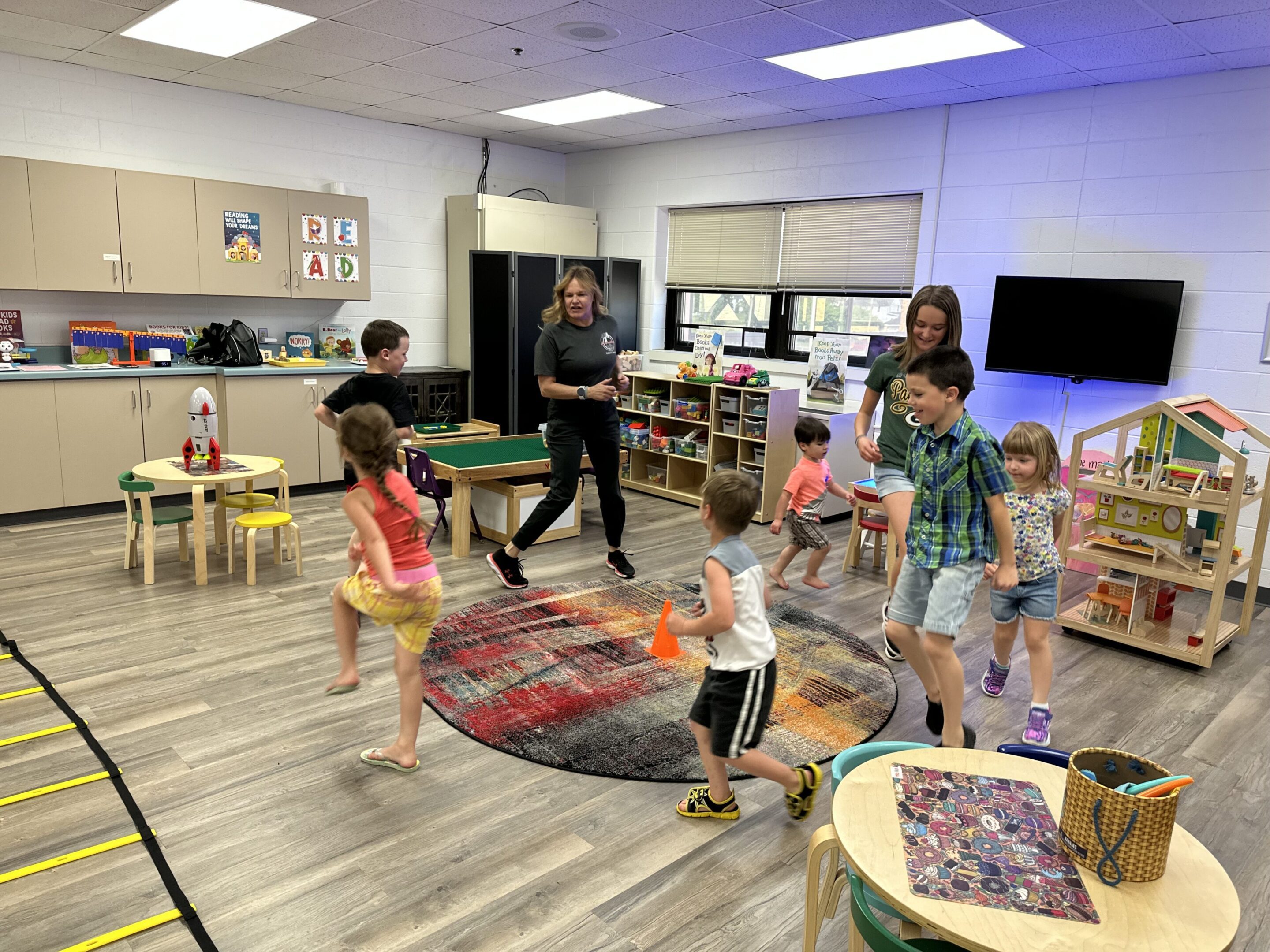 Children participating in a fun group activity indoors with a teacher.