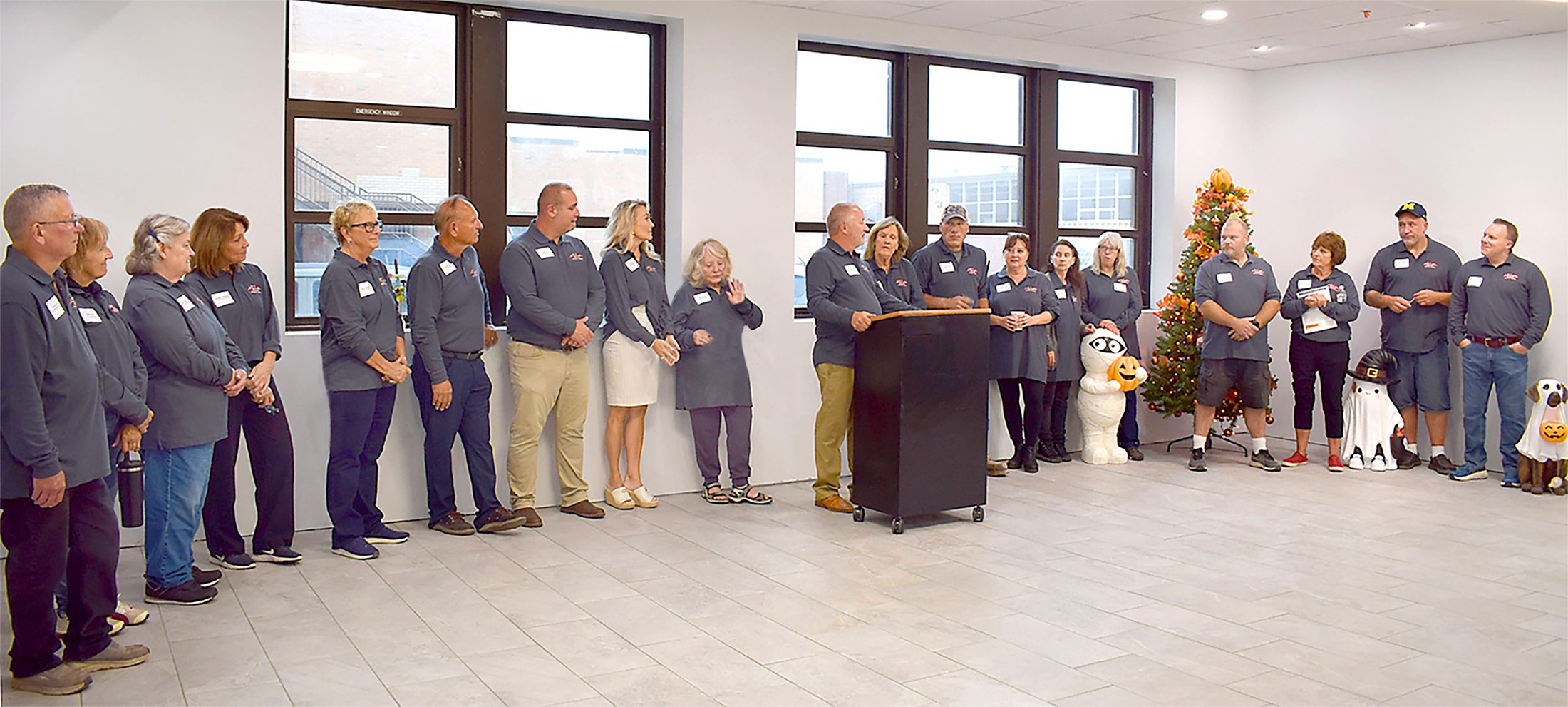 Officials and firefighters gathered for a formal event inside a building.
