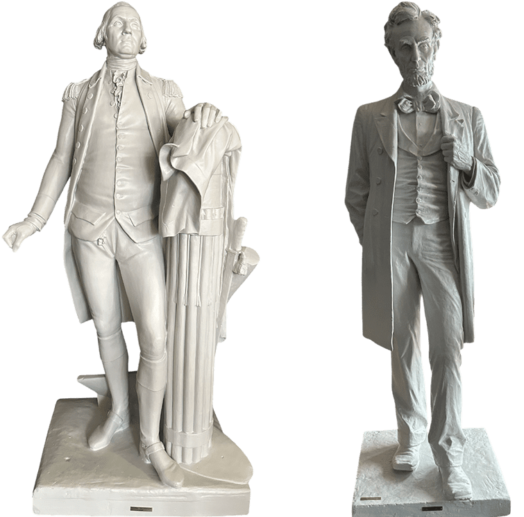 Two white statues of historical men in formal attire.