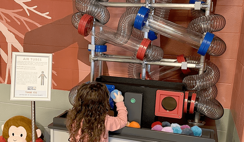 Child playing with a colorful ball drop toy.
